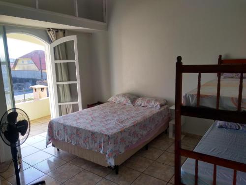 a bedroom with two bunk beds and a balcony at Casa para temporada in Ilha Comprida