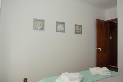 Cette chambre dispose d'un lit avec 3 photos sur le mur. dans l'établissement Vizinha's Apartment, à Ponta Delgada