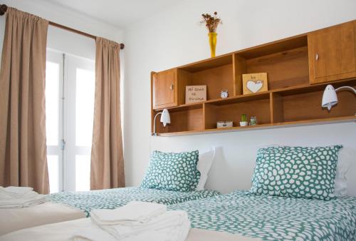 - une chambre avec 2 lits dotés d'oreillers bleus et blancs dans l'établissement Vizinha's Apartment, à Ponta Delgada