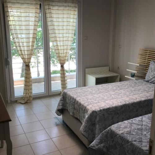 a bedroom with a bed and a large window at Luxurious Apartment Vrasna in Nea Vrasna