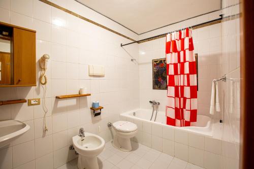 a white bathroom with a toilet and a sink at Hotel Villa Strassoldo "Ex Attianese Hotel Restaurant" in Cervignano del Friuli