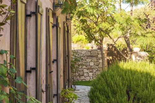 an alley with a stone wall next to a building at Mounty Island Villas Avra-Calma in Lazaráta