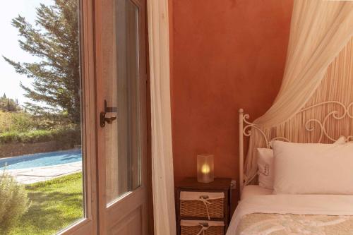 a bedroom with a bed next to a window at Mounty Island Villas Avra-Calma in Lazaráta