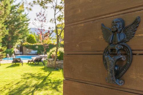 a metal angel on the side of a house at Mounty Island Villas Avra-Calma in Lazaráta