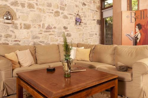 a living room with a couch and a table at Mounty Island Villas Avra-Calma in Lazaráta