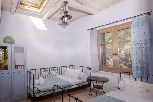 a room with two beds and a window at Mounty Island Villas Avra-Calma in Lazaráta