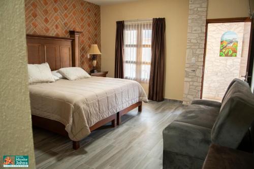 a bedroom with a bed and a couch in it at Mirador Johya Hotel in Bernal