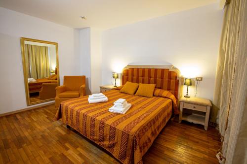 a bedroom with a bed with two towels on it at Hotel Villa Strassoldo "Ex Attianese Hotel Restaurant" in Cervignano del Friuli