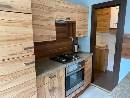 a kitchen with wooden cabinets and a stove top oven at Kawalerka Fredry 3/14 in Poznań