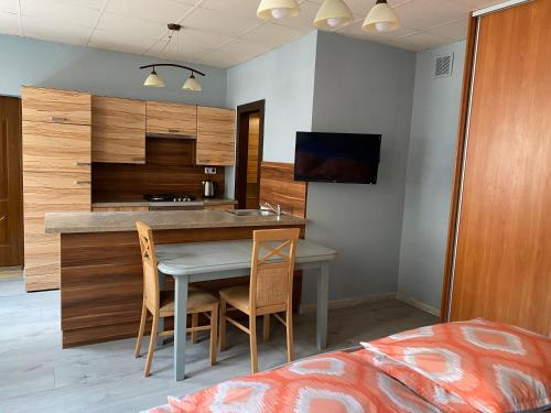 a kitchen with a table and chairs in a room at Kawalerka Fredry 3/14 in Poznań