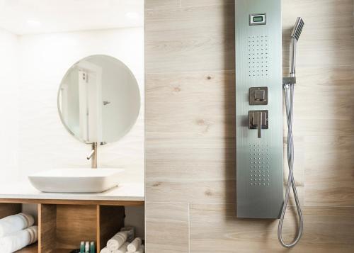 um chuveiro na casa de banho com um lavatório e um espelho em Sun Tower Hotel & Suites on the Beach em Fort Lauderdale