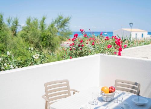 a table with a bowl of fruit on a balcony with flowers at Cavall de Llevant - Formentera Break in Es Caló