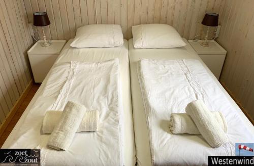 two beds in a room with white sheets and pillows at Holiday-Chalet Westenwind 4p. Amsterdam & Beach in Opmeer