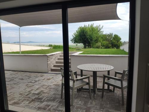 d'une terrasse avec une table et des chaises et une vue. dans l'établissement Panorama & Vino apartman, à Szigliget