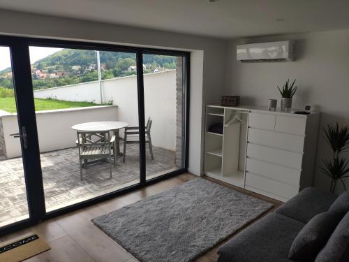 西格利蓋特的住宿－Panorama & Vino apartman，带沙发和桌子的客厅以及阳台。