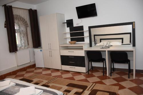 - une cuisine avec un bureau et deux chaises dans la chambre dans l'établissement Royal Castle, à Paşcani