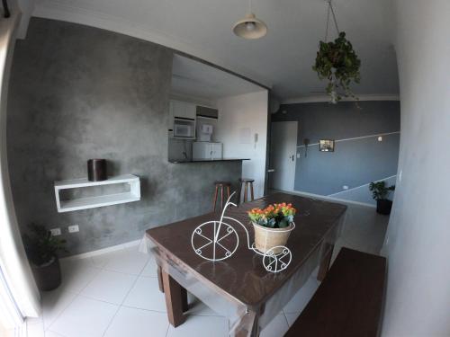 una cocina con una mesa con una bicicleta. en Beach House Itaguá Apartamento 1 - Em Ubatuba a 300m da orla mais charmosa, com excelente localização, en Ubatuba