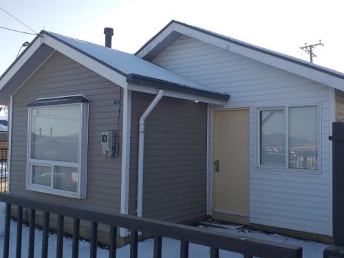 uma pequena casa com um alpendre e uma porta em Greyhouse em Puerto Natales
