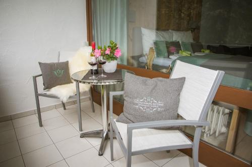 a table with two chairs and a table with wine glasses at Schlosspark Grubhof - Mitterer in Sankt Martin bei Lofer