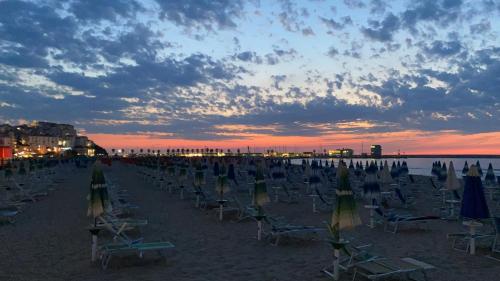 a beach with chairs and umbrellas at sunset at B&B Vista Mare in Rodi Garganico