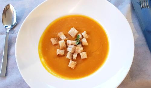 a white plate with a bowl of soup with bread cubes at Hotel Villa Adriana in Monterosso al Mare
