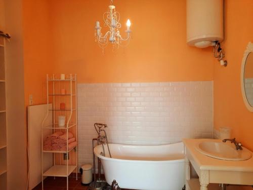 a bathroom with a tub and a sink and a chandelier at Sisi-Schloss Rudolfsvilla - Appartement Elisabeth in Reichenau