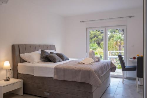 Un dormitorio con una cama grande y una ventana en Apartments Sky, en Vodice
