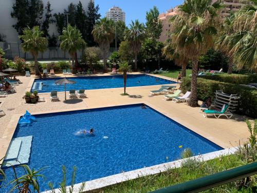 a large swimming pool with a person swimming in it at CORALINE OCEANIC studio vue mer in Portimão