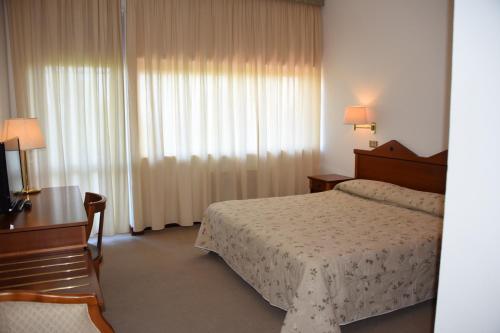 Säng eller sängar i ett rum på hotel michelangelo