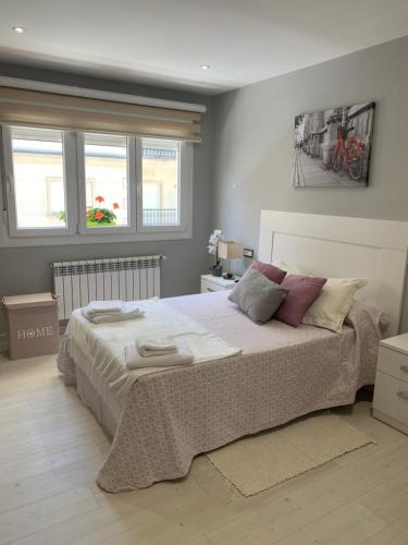 a bedroom with a large bed and two windows at Apartamento Adelina in Silleda