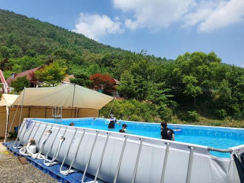 une grande piscine avec des personnes debout autour de celle-ci dans l'établissement CHAEUL Pension, à Pyeongchang