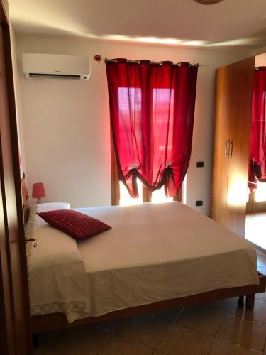 a bedroom with a large bed with red curtains at PRINCESS HOUSE in Ladispoli