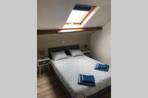 1 dormitorio con 1 cama con 2 almohadas azules en Petite maison à la campagne, en Couvin