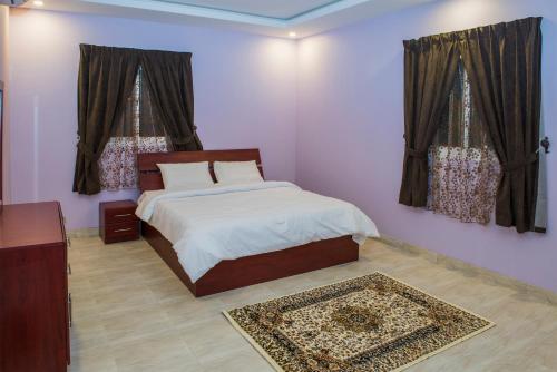 1 dormitorio con 1 cama y 2 ventanas en Najd Peak By Quiet Rooms en Riad