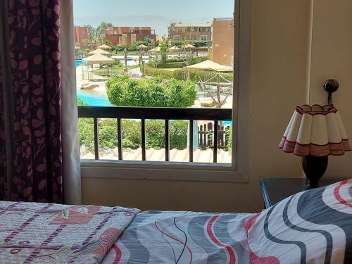 a bedroom with a window with a view of a pool at Marina Wadi Degla Villa Duplex 4 Bedrooms in Ain Sokhna