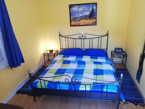 Schlafzimmer mit einem Bett mit einer blauen und weißen Bettdecke in der Unterkunft Cà di Noni in Gordevio