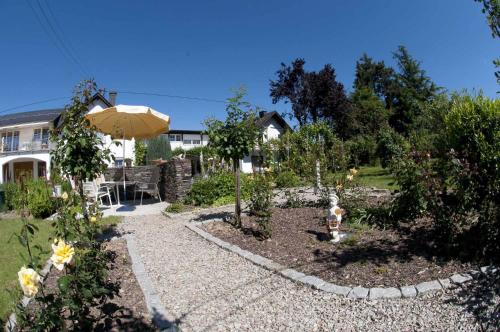 a garden with a fire hydrant and an umbrella at Weingut Fries in Maring-Noviand