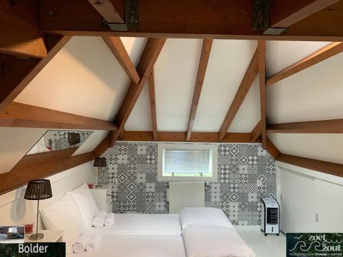 a bedroom with a white bed and wooden ceilings at Wellness Bungalow Bolder 5p Amsterdam and the beach in Opmeer