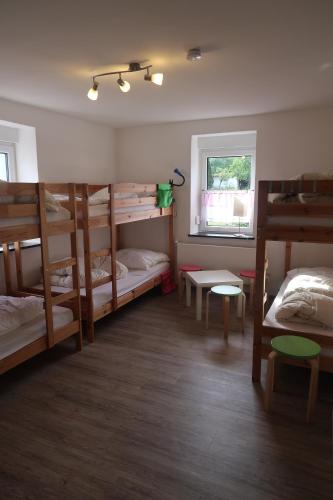 a room with three bunk beds and a window at Landpension zur Hainbuche in Romrod