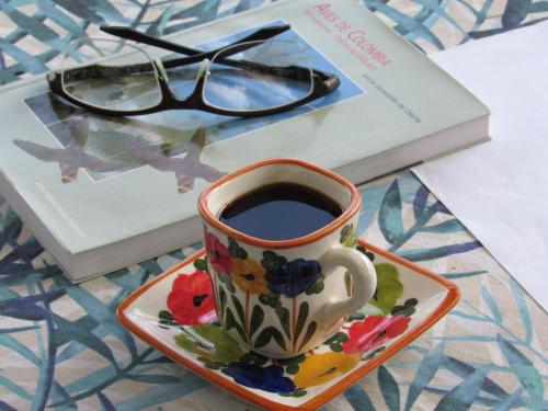 Una taza de café en un plato junto a un libro. en Reserva Guadalajara - Cocora Valley, en Salento