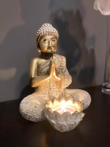 una estatua de una mujer sentada junto a una vela en Green Lodges, en Blaregnies