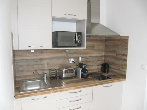 une cuisine avec un évier et un micro-ondes dans l'établissement Studio Barbel, à Honfleur