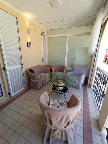 a living room with a glass table and chairs at aMare il mare in Porto Recanati