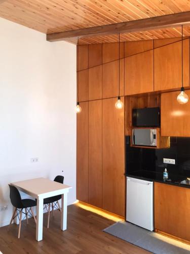 a kitchen with a table and a microwave and a table and chairs at Estúdio Azul in Ponta Delgada