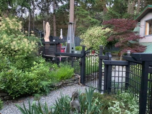 a black fence in a garden with a cemetery at Salt Spring Carriage House B&B in Ganges