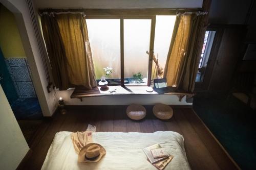 Una chica está mirando por una ventana en un dormitorio en Leranda Homestay, en Hue