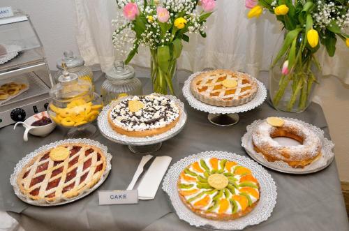 een tafel vol taarten, wafels en bloemen bij Hotel San Giuliano in Mestre