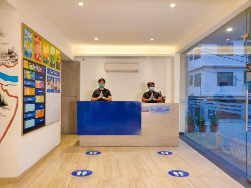 two people wearing face masks sitting at a counter at Blue Jay Hostel Rishikesh in Rishīkesh