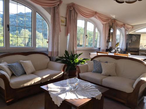 a living room with two couches and a table at Villa Maria in Dorgali