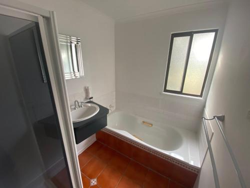 a bathroom with a tub and a sink and a window at Aperture in Coles Bay